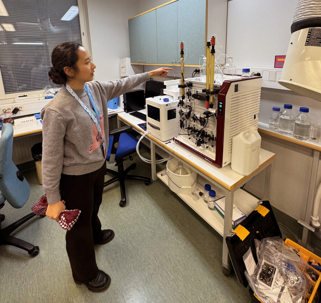 One person in lab environment pointing at equipement.